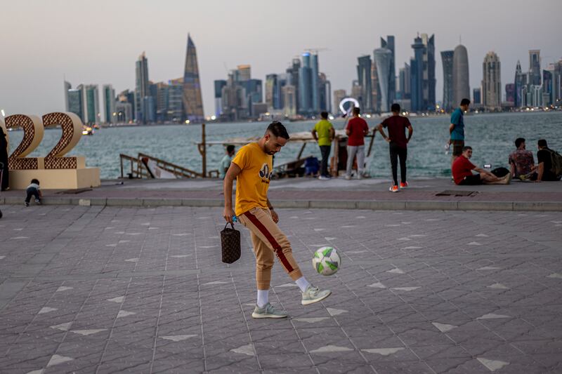 Un hombre hace malabares con un balón en el área de Corniche en Doha, Qatar